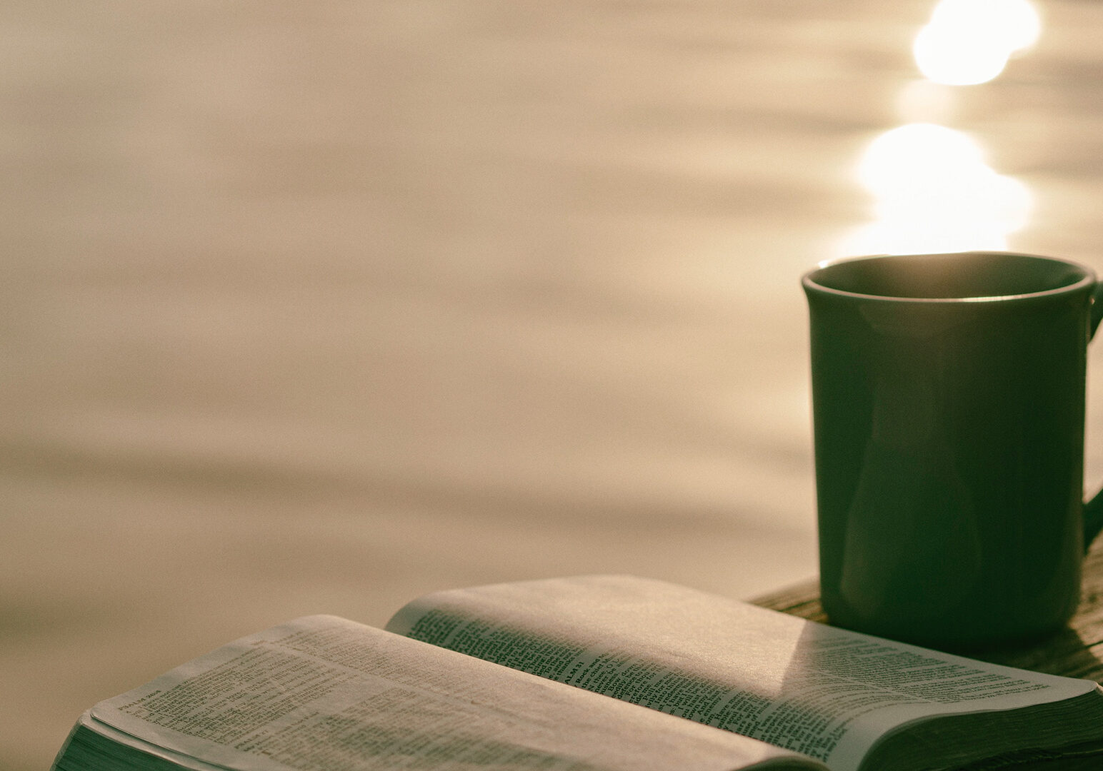 green-ceramic-mug-beside-book